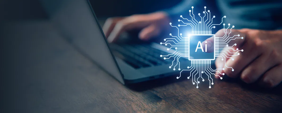 AI Masterclass Person arbeitet an einem Laptop, daneben leuchtet ein KI-Symbol mit der Aufschrift ‚AI‘ in einem digitalen Schaltkreis