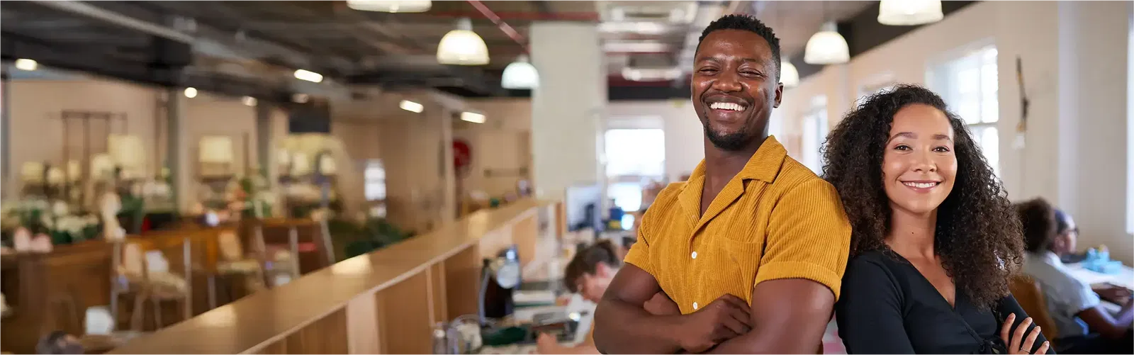 Erfahre mehr über elio als Arbeitgeber. Ein Mann und eine Frau lachen gemeinsam in die Kamera und haben ihre Arme verschränkt.