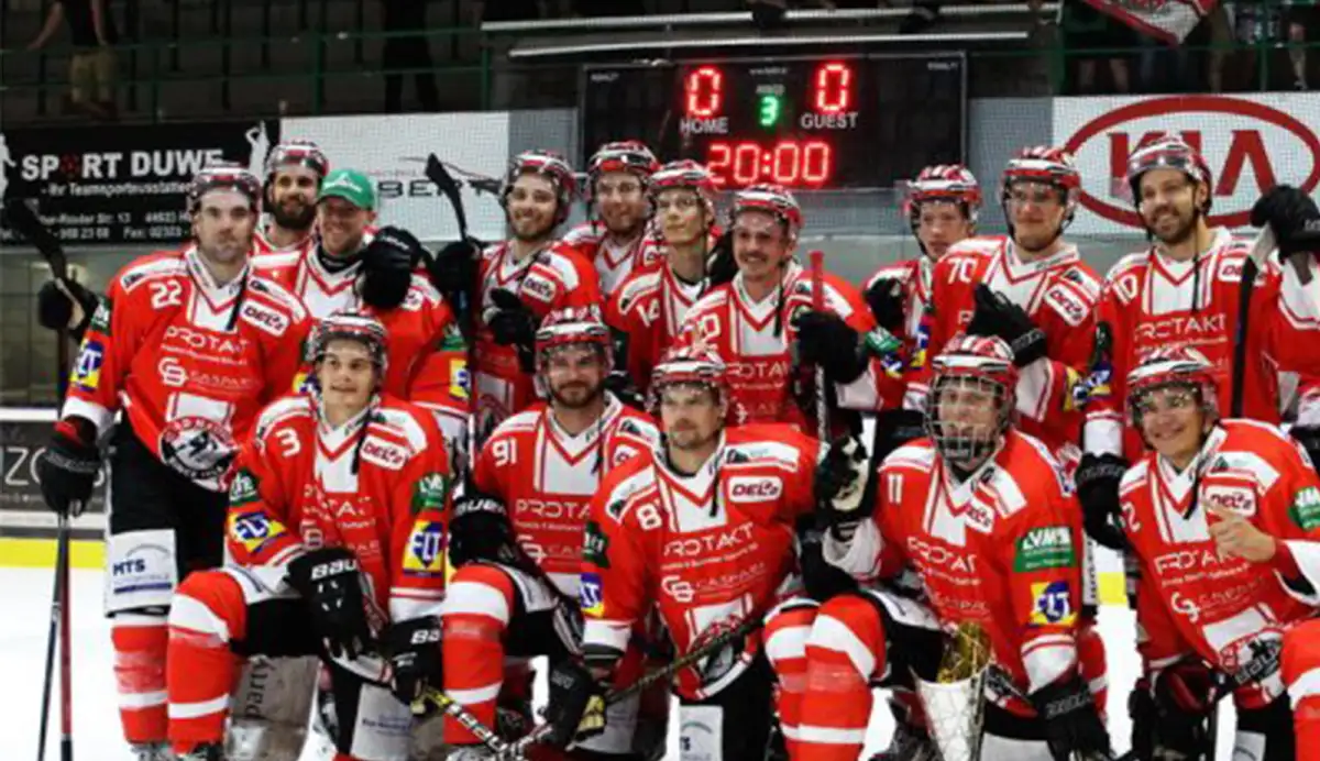 EC Bad Nauheim Eine Eishockeymannschaft posiert mit ihrer Ausrüstung auf dem Eisfeld für ein Foto