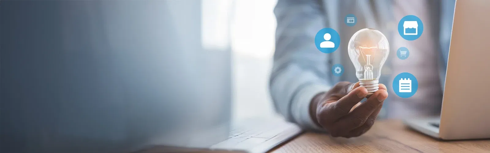 Person hält eine Glühbirne mit digitalen Symbolen rundherum – steht für innovative Ideen und technologische Integration im Unternehmen