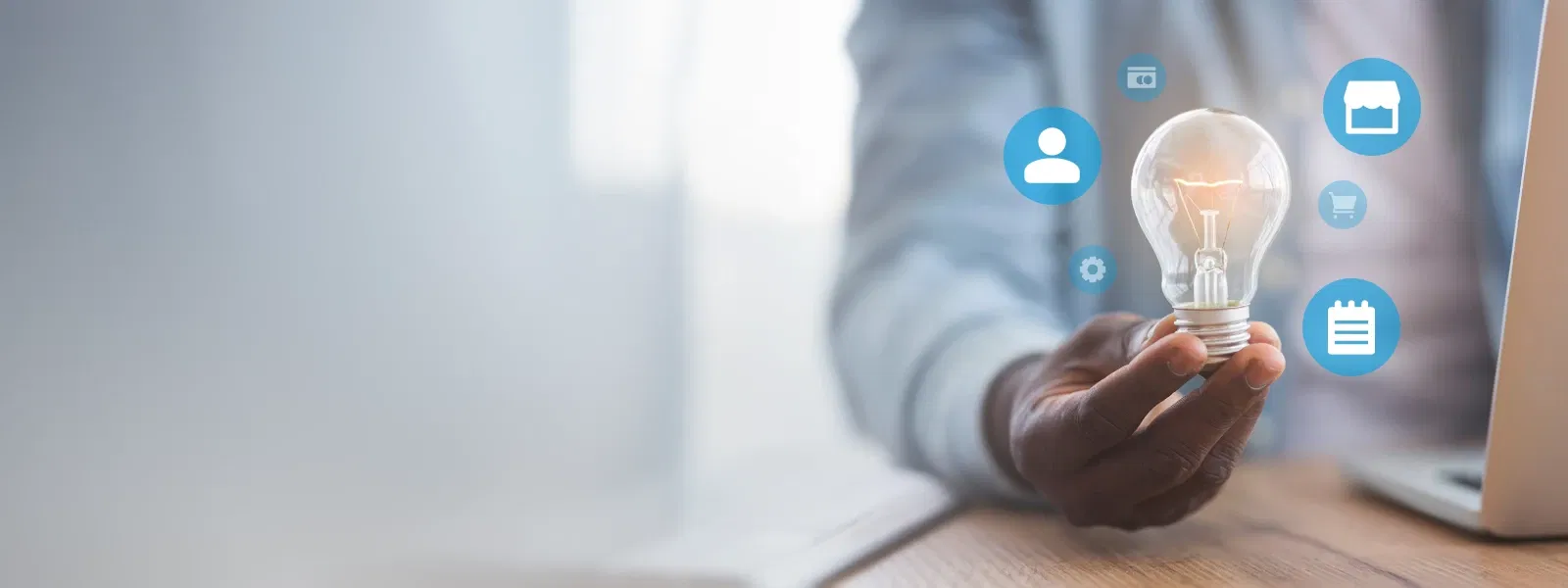 Person hält eine Glühbirne mit digitalen Symbolen rundherum – steht für innovative Ideen und technologische Integration im Unternehmen