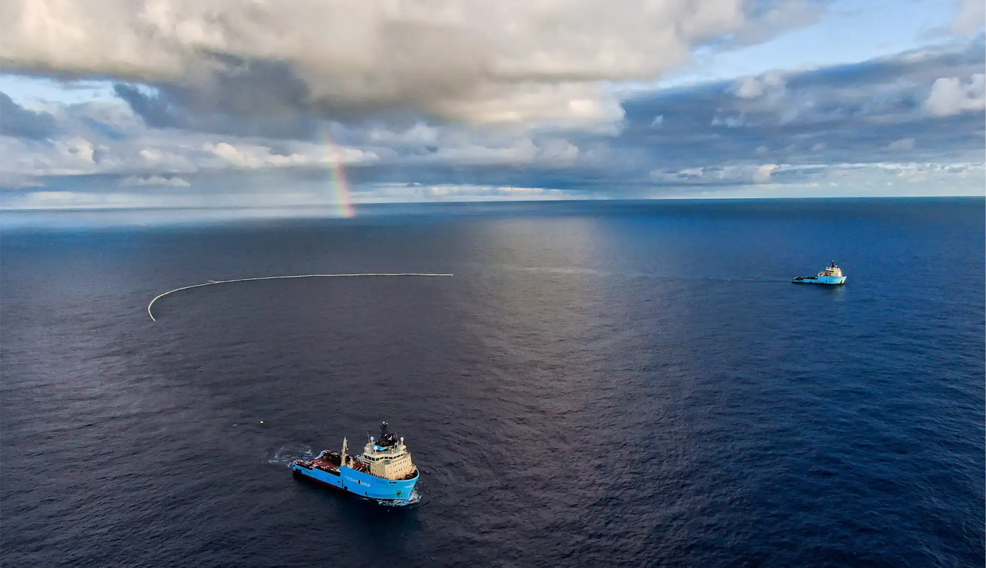 The Ocean Cleanup Zwei Schiffe fahren übers Meer und Sammeln mit einem Netz, welches zwischen den beiden Schiffen gespannt ist.