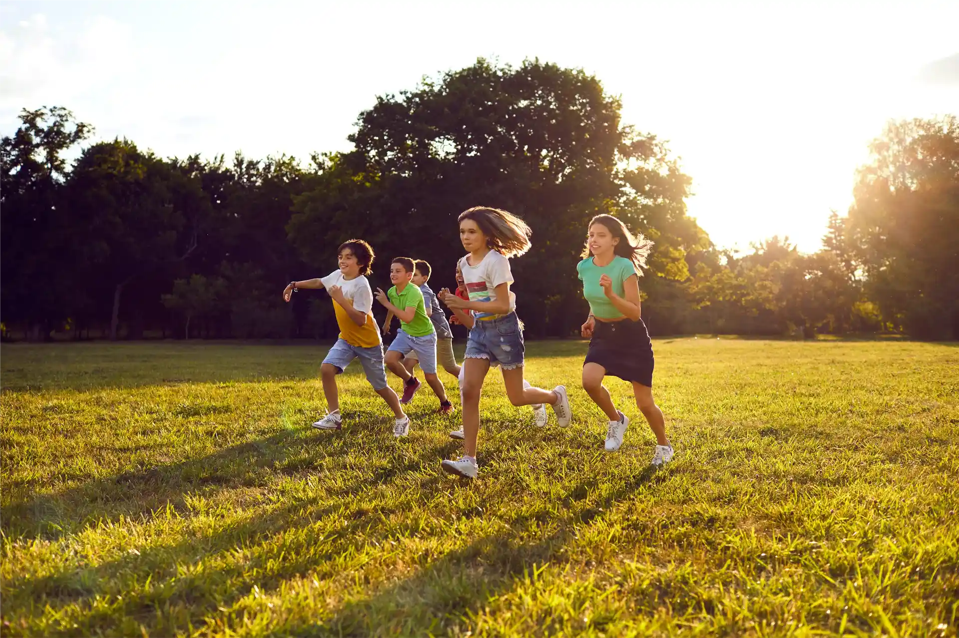 Soziale Projekte. Mehrere Kinder laufen spielend über eine Wiese.